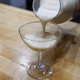 Pouring coquito into a glass (photo courtesy of Jessica Von Dopp de Jesus)